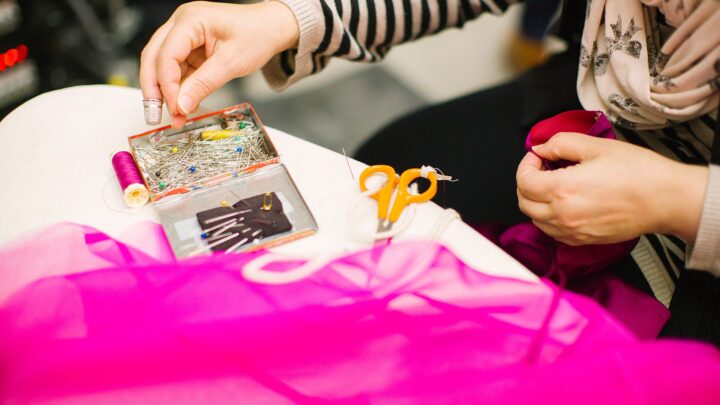 Bancada de costura com alfinetes, tesoura e tecido
