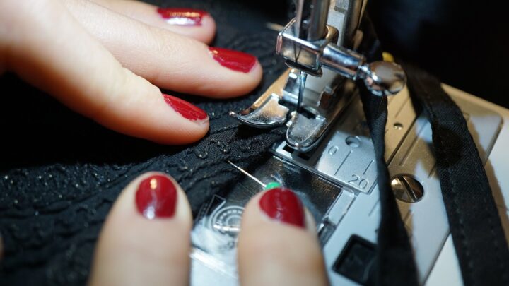 Costureira montando peça de renda em máquina industrial